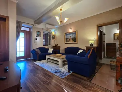 a living room with blue couches and a table at Sicilija in Podgorica
