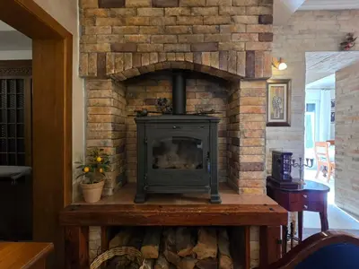 a stone fireplace in a living room with a stove at Sicilija in Podgorica