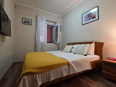 a bedroom with a bed with a yellow blanket at Sicilija in Podgorica