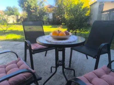 a bowl of fruit on a table with two chairs at Sicilija in Podgorica