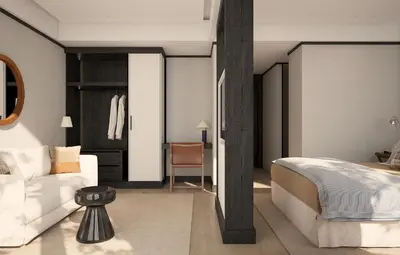 a bedroom with a white bed and a white couch at Hotel Madeira in Budva