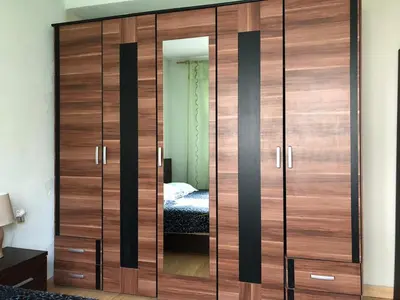 a large wooden wardrobe in a bedroom with a bed at Apartments Dubrava 106 in Dobra Voda