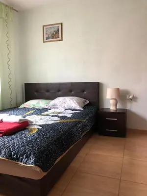 a bedroom with a bed and a night stand with a lamp at Apartments Dubrava 106 in Dobra Voda