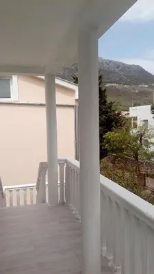 a balcony with white columns and a view of a mountain at Apartments Dubrava 106 in Dobra Voda