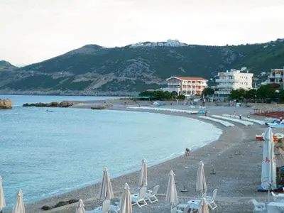 a beach with chairs and umbrellas and the ocean at Apartments Dubrava 106 in Dobra Voda