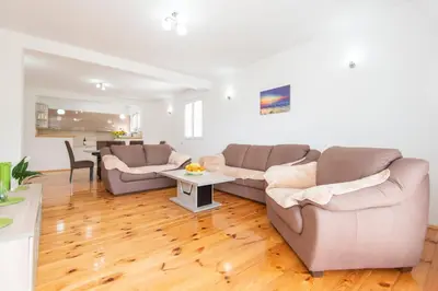 a living room with two couches and a table at GALIOT Apartment in Škaljari