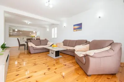 a living room with two couches and a table at GALIOT Apartment in Škaljari