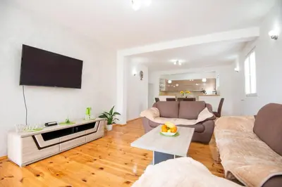 a living room with a couch and a tv at GALIOT Apartment in Škaljari