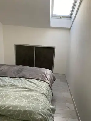 a bed in a white room with a window at Andrea Apartment in Podgorica