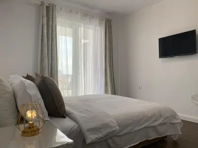 a bedroom with a bed and a window at Veselinka Apartments & Rooms in Budva
