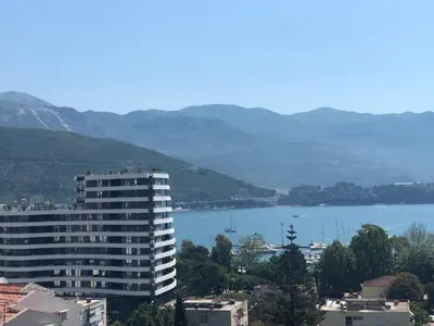 a building with a view of a lake and mountains at Veselinka Apartments & Rooms in Budva