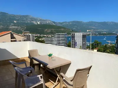 a table and chairs on a balcony with a view at Veselinka Apartments & Rooms in Budva