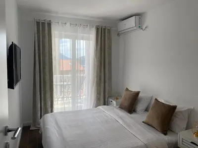 a bedroom with a white bed and a window at Veselinka Apartments & Rooms in Budva