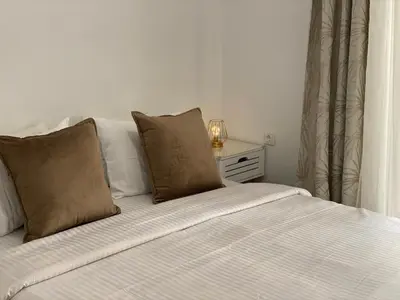 a white bed with two pillows on top of it at Veselinka Apartments & Rooms in Budva