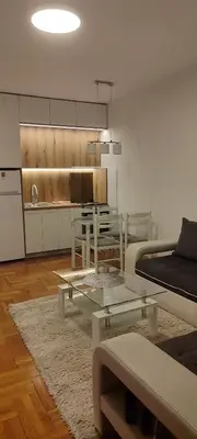 a living room with a table and a kitchen at Rajka Lux in Podgorica