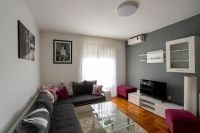 a living room with a couch and a tv at Rajka Lux in Podgorica