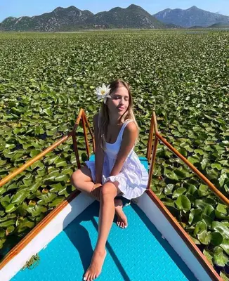 a girl sitting on a boat in a field of lilies at Apartments Four Countesses in Virpazar