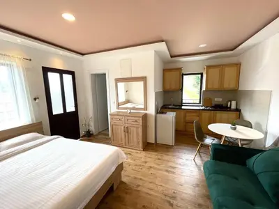 a bedroom with a bed and a table and a kitchen at Apartments Four Countesses in Virpazar