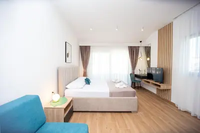 a hotel room with a bed and a tv at Apartments Sirena - Modern stay with free parking in Budva