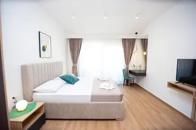 a hotel room with a bed and a television at Apartments Sirena - Modern stay with free parking in Budva