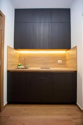 a kitchen with a sink and black cabinets at Apartments Sirena - Modern stay with free parking in Budva