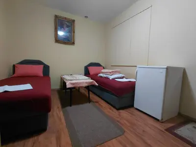 a room with two beds and a refrigerator at Snežana in Budva