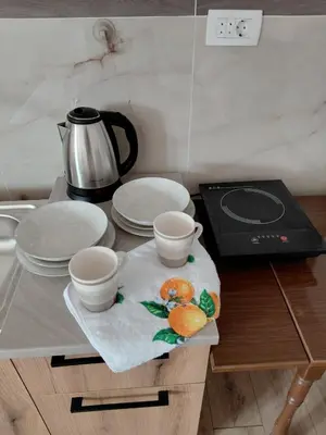 a table with plates and cups and a coffee pot at Studio apartman Milena 1 in Podgorica