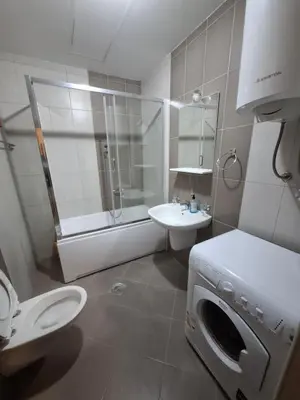 a bathroom with a washing machine and a sink at Ljubovic prestige apartment in Podgorica