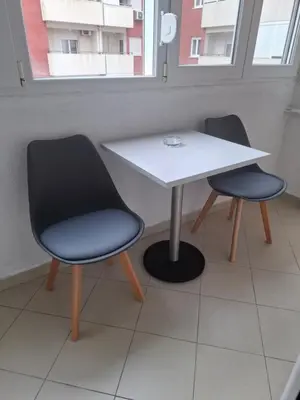 two chairs and a white table in a room at Ljubovic prestige apartment in Podgorica