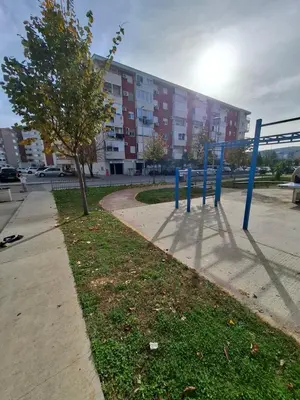 a park with blue poles in front of a building at Ljubovic prestige apartment in Podgorica