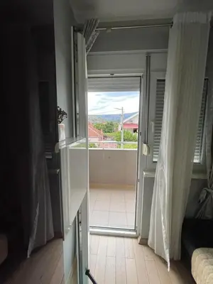 a door to a balcony with a view of a room at Apartment Peace in Podgorica