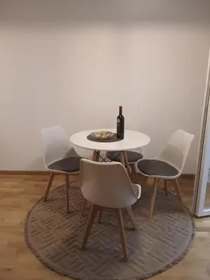 a table with four chairs and a bottle of wine at Studio apartman in Budva