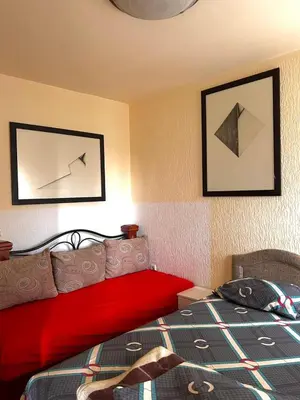 a bedroom with a red bed and two pictures on the wall at Apartmani Vila Marija in Budva