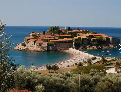 a beach with a group of people and boats in the water at Apartmani Vila Marija in Budva