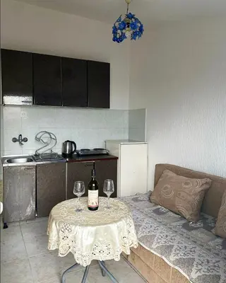 a table with a bottle of wine and two glasses on it at Apartmani Vila Marija in Budva