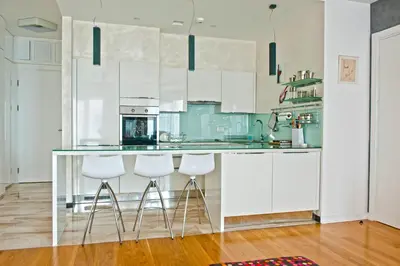 a kitchen with white cabinets and a counter with stools at DeLux and Urban apartments Hotel Tre Canne Budva in Budva