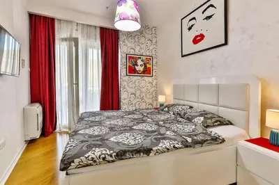 a bedroom with a bed with a black and white comforter at DeLux and Urban apartments Hotel Tre Canne Budva in Budva
