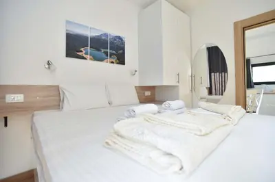 a white bedroom with two beds with towels on them at Lux Čanj in Čanj