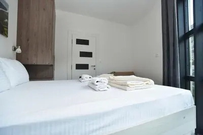 a bedroom with a white bed with towels on it at Lux Čanj in Čanj