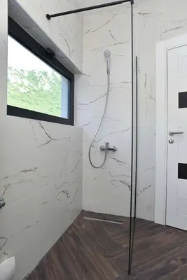a bathroom with a shower with a window at Lux Čanj in Čanj