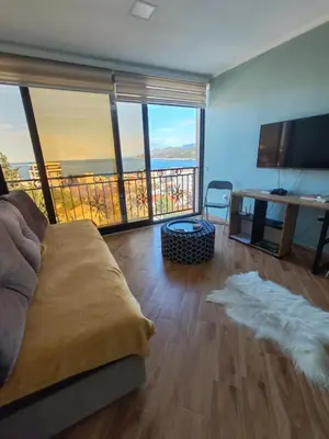 a living room with a couch and a view of the ocean at Cherry in Dobra Voda