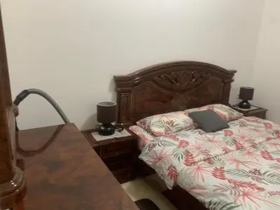 a bedroom with a bed and two night stands with lamps at Apartman SA&BO in Podgorica