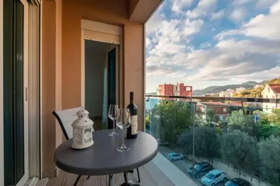 a table with two bottles and two wine glasses on a balcony at Obrad Pržno See View in Kamenovo
