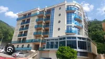 a large building with cars parked in front of it at Obrad Pržno See View in Kamenovo