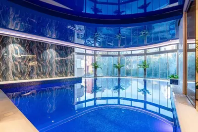 an indoor pool with palm trees in a building at Obrad Pržno See View in Kamenovo