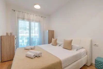 a bedroom with a large white bed with towels on it at Obrad Pržno See View in Kamenovo