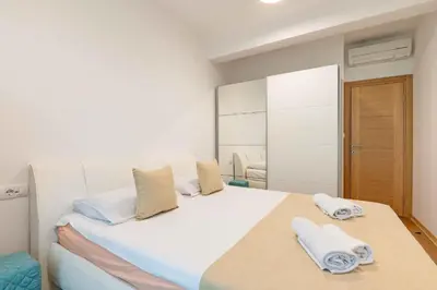 a bedroom with a large white bed with towels on it at Obrad Pržno See View in Kamenovo