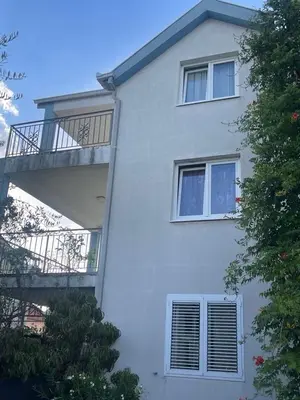 a white house with a balcony on the side of it at Duplex apartment in Podgorica in Podgorica