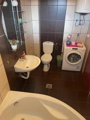 a bathroom with a toilet sink and a washing machine at Duplex apartment in Podgorica in Podgorica