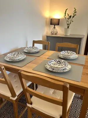 a wooden table with four chairs and plates on it at Stay In Bar in Bar